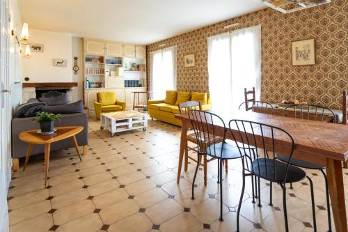 un salon avec un canapé, une table et des chaises dans l'établissement Maison de campagne au calme, à La Selle-en-Hermoy