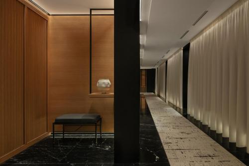 a corridor with a chair in a building at Delano Dubai at Bluewaters in Dubai