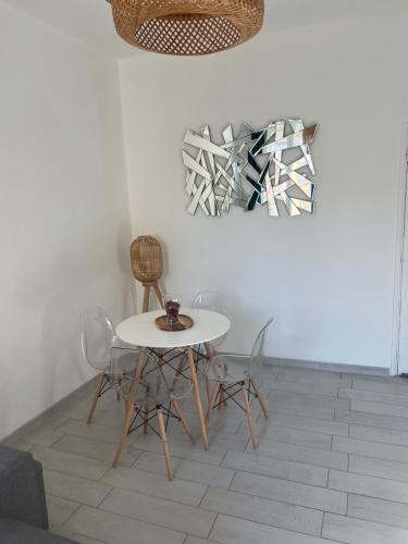 - une table et des chaises blanches dans la chambre dans l'établissement Charmant T2 climatisé a 5 min de là gare st-charles - vieux port, à Marseille