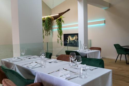 a dining room with white tables and green chairs at Chez Agnès in Auzéville-en-Argonne