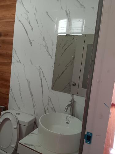 a bathroom with a toilet and a sink and a mirror at Maruay villa beach in Suratthani