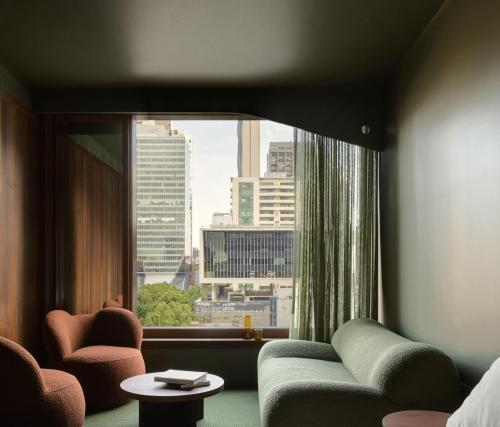 a living room with a couch and a window at Hyde Melbourne Place in Melbourne