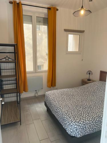 une chambre avec un lit et une fenêtre avec des rideaux orange dans l'établissement Charmant T2 climatisé a 5 min de là gare st-charles - vieux port, à Marseille