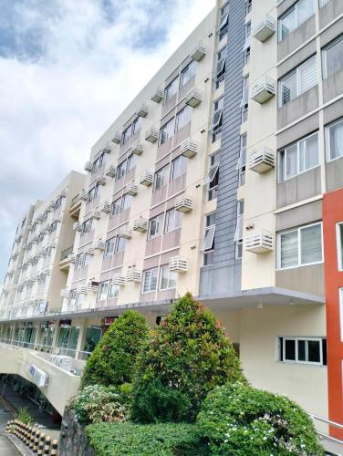 an apartment building with bushes in front of it at Stanford Suites 2 Condo Hotel in Santo Domingo