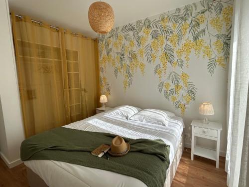 une chambre avec un lit avec un chapeau dessus dans l'établissement Le Serenity - lit XL, Parking, Proche Centre, à Rodez