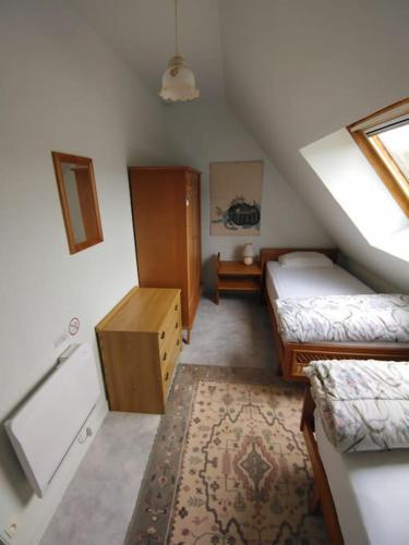 une petite chambre mansardée avec deux lits et un tapis dans l'établissement Longère normande en Pays de Caux, à Grainville-la-Teinturière