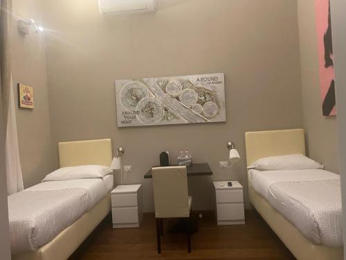 a room with two beds and a table in it at Residenza Segrate Centro Novegro in Segrate