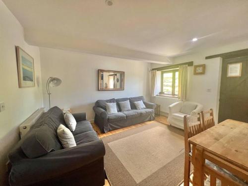 a living room with a couch and a table at 3 bedroom barn conversion with swimming pool, tennis court and more! in Kingsbridge