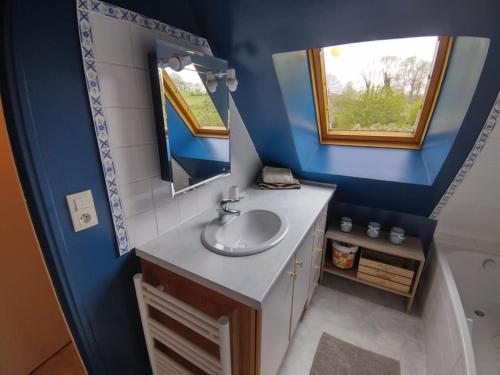 une salle de bain avec un lavabo et un miroir dans l'établissement Longère normande en Pays de Caux, à Grainville-la-Teinturière