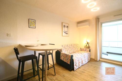 un salon avec une table et un canapé dans l'établissement Delyos, climatisation et plage, à Saint-Mandrier-sur-Mer