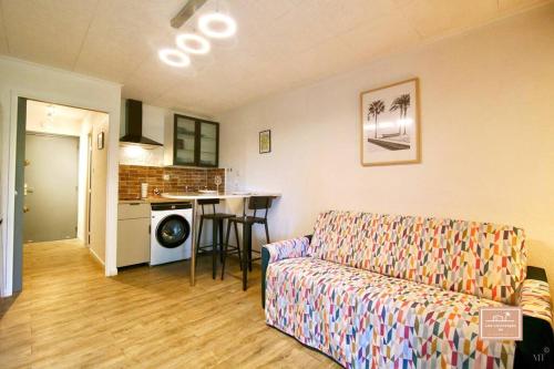 un salon avec un canapé et une cuisine dans l'établissement Delyos, climatisation et plage, à Saint-Mandrier-sur-Mer