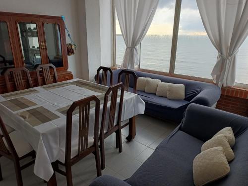 ein Esszimmer mit Tisch und Stühlen und einem großen Fenster in der Unterkunft Tucacas Penthouse w Generator and Water Tank in Tucacas