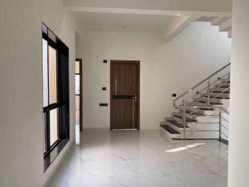 a hallway with stairs and a wooden door at Nirant Villa in Indore