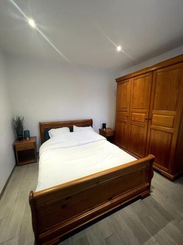 - une chambre avec un grand lit et des placards en bois dans l'établissement Maisonnette des Douves Plein Centre 1 à 4 voyageurs, à Malestroit
