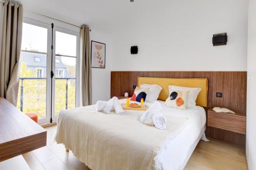 une chambre avec un lit avec des serviettes dessus dans l'établissement Bluestay 296 - Superbe appartement à Paris 17, à Paris