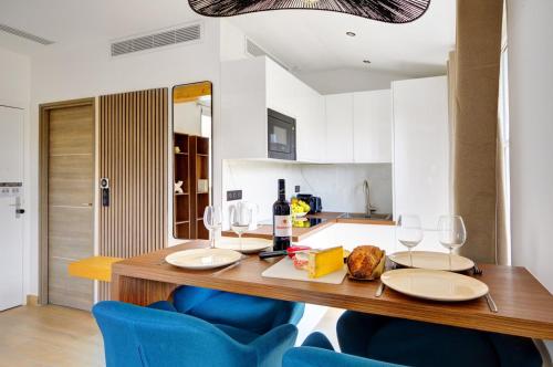 une cuisine avec une table en bois et des chaises bleues dans l'établissement Bluestay 296 - Superbe appartement à Paris 17, à Paris