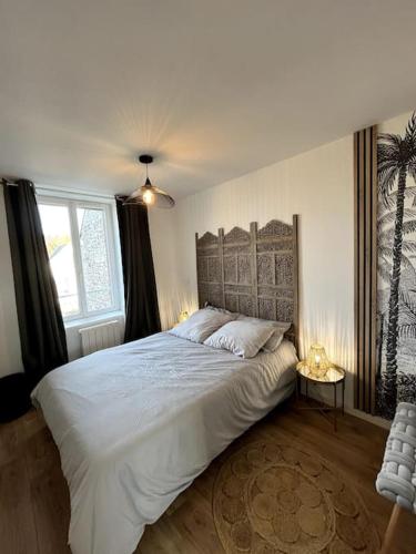 une chambre avec un grand lit et une fenêtre dans l'établissement le privilège - 400m de la gare, à Saint-Brieuc