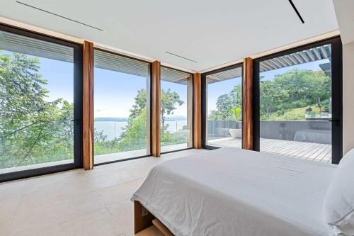 een slaapkamer met een bed en grote ramen bij Luxurious Villa in Papagayo in Nacascolo