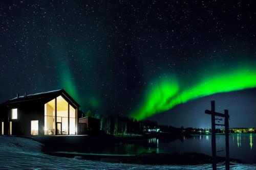 an image of the northern lights in the sky over a church at Stay North - The House of Northern Lights in Äkäslompolo