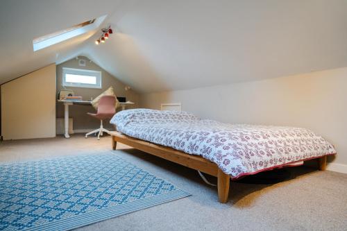 a bedroom with a bed and a desk in a attic at Acer View in Leeds