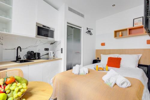 Cette chambre comprend 2 lits et une table avec un bol de fruits. dans l'établissement Bluestay 291 - Studio Cozy à Paris, à Paris