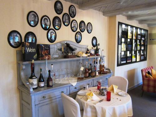 a room with a table and a bunch of wine bottles on the wall at Landhotel Hirschen in Trüllikon
