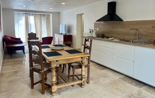 a kitchen with a wooden table with chairs and a sink at Symphonie Gîte Appartement meublé in Gréoux-les-Bains