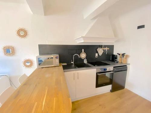 une cuisine avec un comptoir en bois dans une pièce dans l'établissement Appartement à 20mètres du port de Sanary, à Sanary-sur-Mer