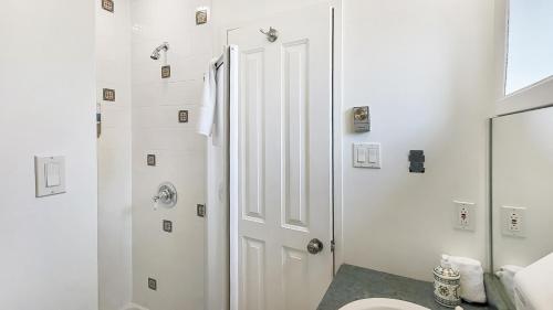 a white bathroom with a toilet and a shower at InstantSuites- The Mountain Lake house in Mont-Tremblant