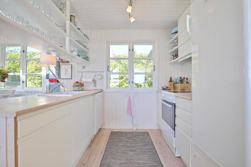 a white kitchen with white cabinets and a sink at Nice Home In Ebeltoft With 2 Bedrooms in Knebel