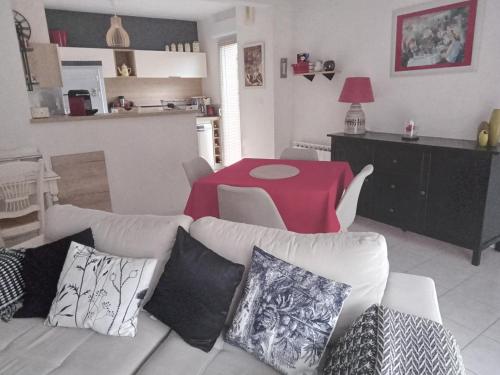 - un salon avec un canapé blanc et une table rouge dans l'établissement parc de la dérobée, à Saint-Agathon