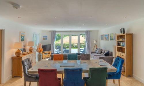 a living room with a dining room table and chairs at Trewhiddle Retreat V9 by Together Travel - Luxury 4-Bedroom Villa in St Austell
