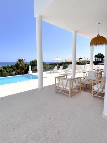 a white pavilion with chairs and a swimming pool at Atalaya Boutique in Denia