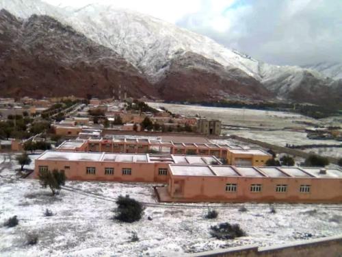 a group of buildings in front of a snow covered mountain at Adil Guest House in Nzala