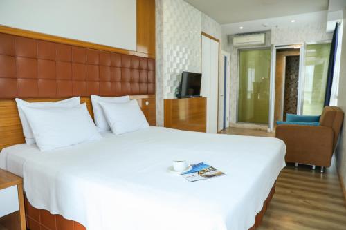 a bedroom with a large white bed with a book on it at The Hera Platinum Hotel in Istanbul