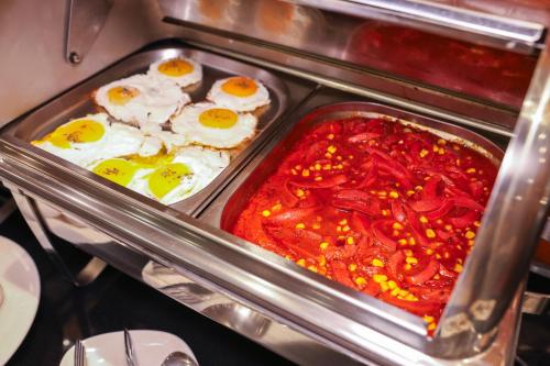 an oven with eggs and peppers in red sauce at The Hera Platinum Hotel in Istanbul