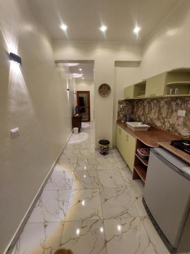 eine Küche mit Fliesenboden und einer Theke in der Unterkunft Carter Guesthouse Luxor 2 in ‘Ezbet Abu Ḥabashi