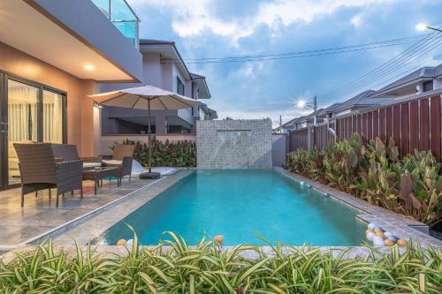 a swimming pool in the backyard of a house at Southern Peak Pool Villa Huay Yai Pattaya in Ban Huai Yai