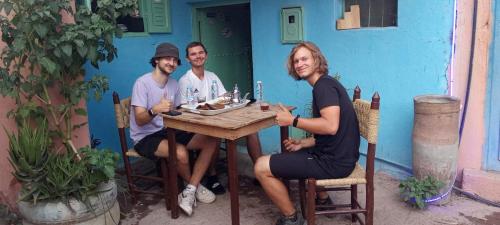 a group of three people sitting at a table at Adil Guest House in Nzala