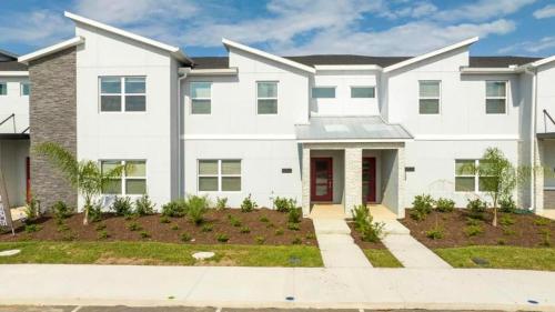 a large white house with a driveway at 2557 Awesome Family 4BD Townhouse located at Storey Lake in Kissimmee