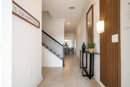 a hallway with white walls and a hallway with a stairway at 2557 Awesome Family 4BD Townhouse located at Storey Lake in Kissimmee
