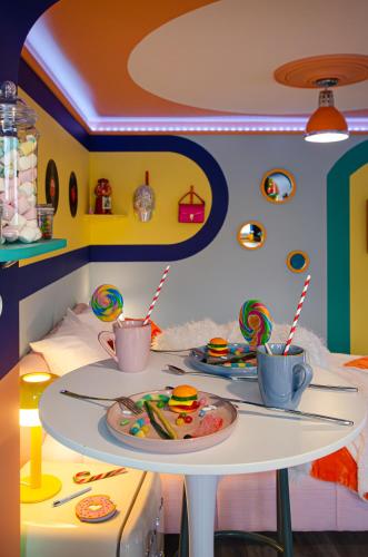 Cette chambre comprend une table avec des assiettes de nourriture. dans l'établissement Retro Candy Lounge, avec terrasse et parking, à Ban-Saint-Martin