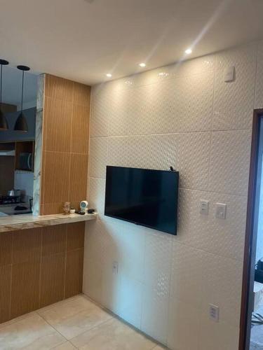 a flat screen tv on the wall of a kitchen at AP a 5 minutos do aeroporto ótima localização in Bayeux