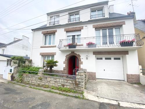 une maison blanche avec une porte rouge dans l'établissement Appartement Douarnenez, Treboull hag ar mor, à Douarnenez