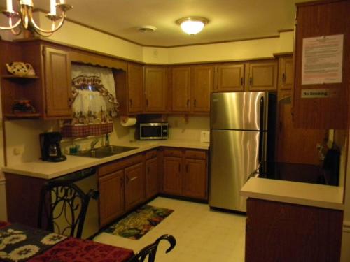 a kitchen with wooden cabinets and a stainless steel refrigerator at Welcome to the Wildwoods Hershey PA in Manor Acres