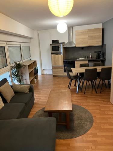 a living room and kitchen with a couch and a table at Grand studio centre ville St Pierre in Cholet