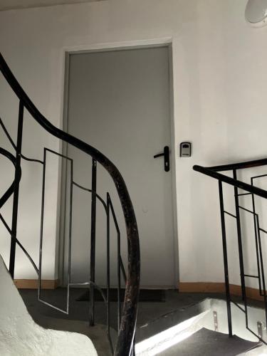 a white door with a metal railing in a room at Grand studio centre ville St Pierre in Cholet