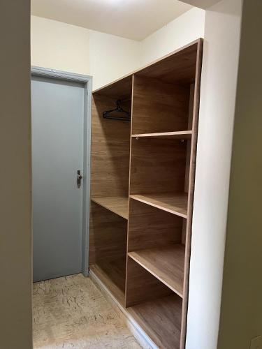 a closet with wooden shelves next to a door at Hotel Muller in Mariana