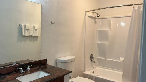 a bathroom with a toilet and a sink and a shower at Weekly Inn in Jacksonville