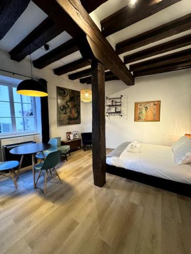 une chambre avec un lit, une table et des chaises dans l'établissement Suite Schwendi - Le petit tanneur - en Hypercentre, à Colmar